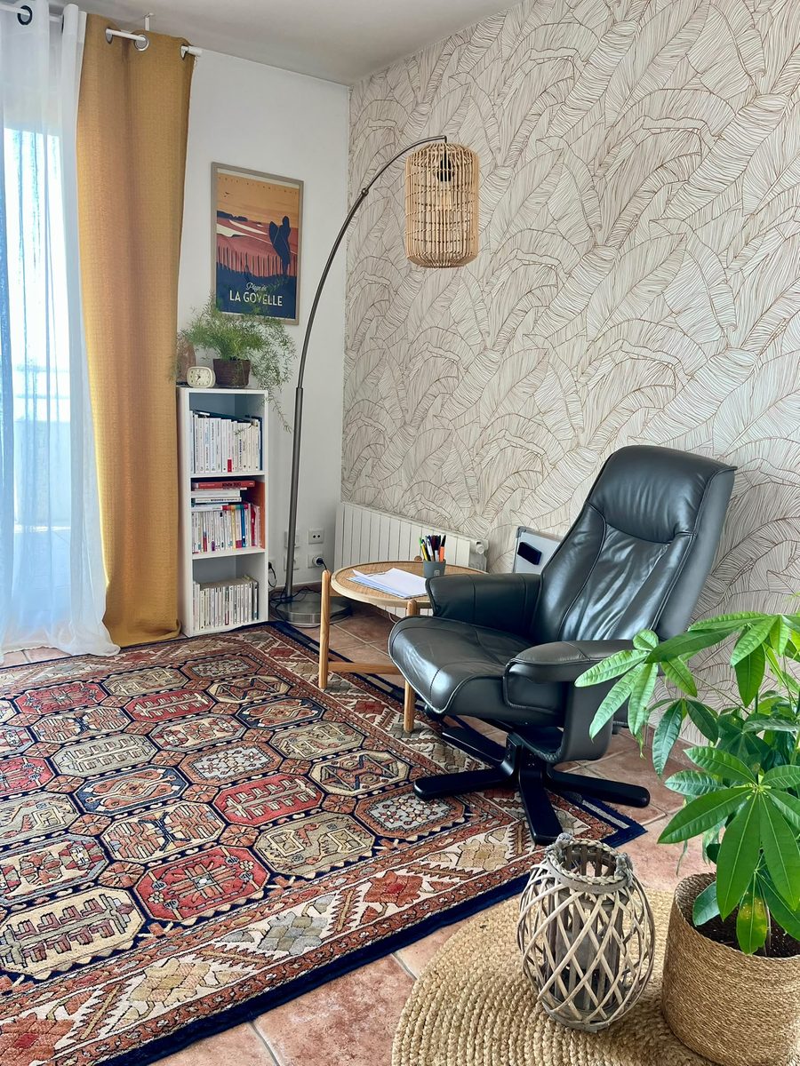 Espace de consultation avec bibliothèque et fauteuil en cuir